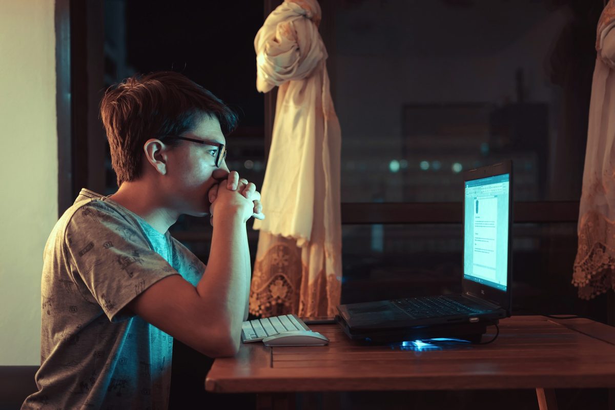 kiskamasz ül a laptop előtt