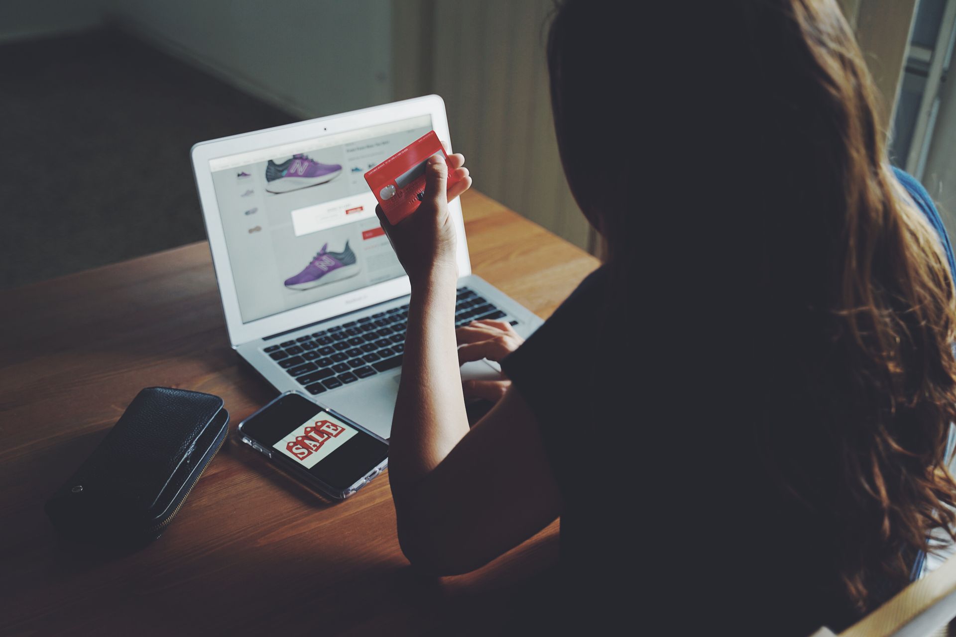 nő háttal ül a laptopnál, és online vásárol